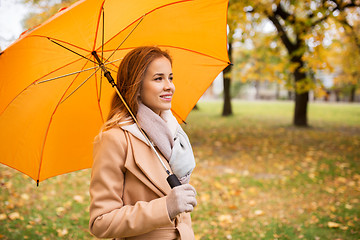 Image showing happy woman with umbrella walking in autumn park