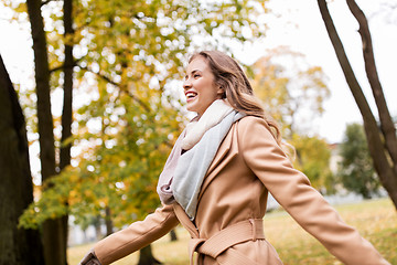 Image showing beautiful happy young woman walking in autumn park