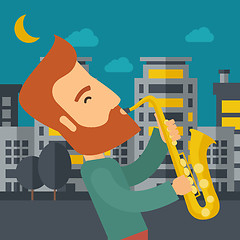 Image showing Saxophonist playing in the streets at night