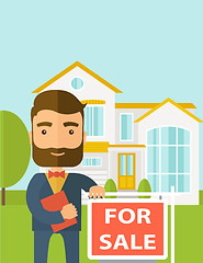 Image showing Real estate agent standing beside the for sale placard.