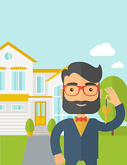 Image showing Real estate agent holding a key infront of the house