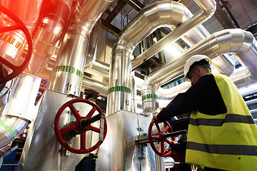 Image showing factory worker turning valve