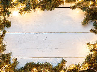 Image showing Christmas background with fir tree and lightbulb on wooden board