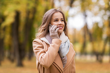 Image showing woman calling on smartphone in autumn park