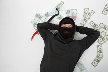 Image showing Robber on floor with money