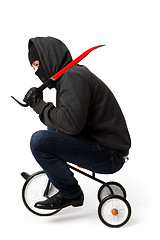Image showing Burglar going on little bicycle