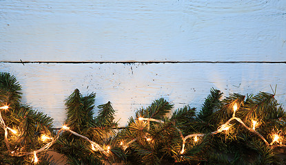 Image showing Christmas lighted fir tree over wooden background with copyspace