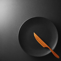 Image showing Black plate with knife on a background.