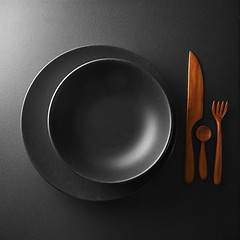 Image showing serving of black table with dark wooden utensils and cutlery