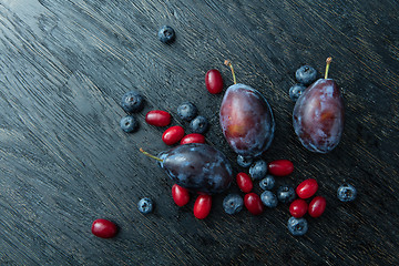 Image showing Fresh plums on a dark wooden table