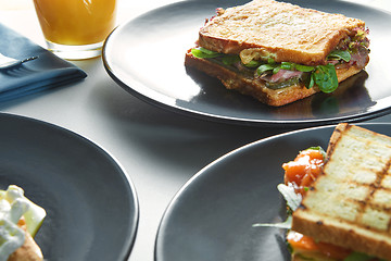 Image showing breakfast of eggs, sandwiches and orange juice