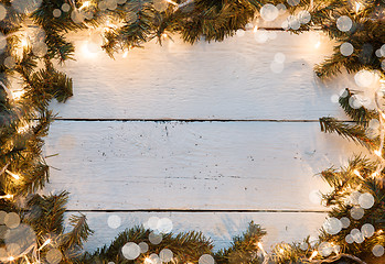 Image showing Christmas wooden bokeh background with fir tree and lighted garladnd