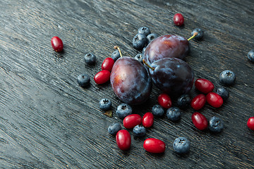 Image showing Fresh plums on a dark wooden table