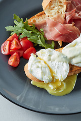 Image showing Eggs Benedict with bacon, toast and salad.