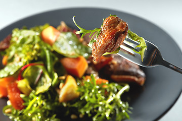 Image showing baked pumpkin, steak and arugula on a fork