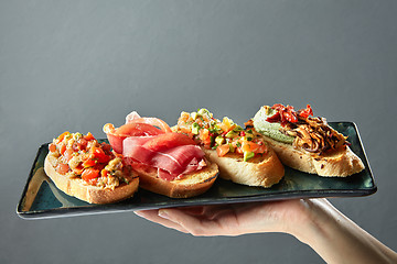 Image showing delicious variety of Italian bruschetta on a ceramic tray