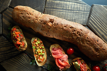 Image showing mini bruschetta with tomatoes, salmon, avocado, bacon, and basil butter