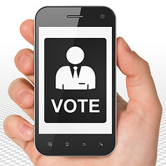 Image showing Political concept: Hand Holding Smartphone with Ballot on display