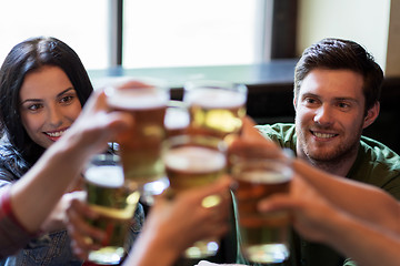 Image showing happy friends drinking beer at bar or pub