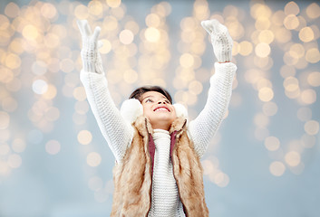 Image showing happy little girl wearing earmuffs over lights