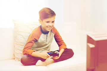 Image showing happy boy with joystick playing video game at home