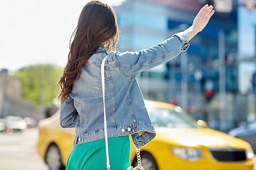 Image showing young woman or girl catching taxi on city street