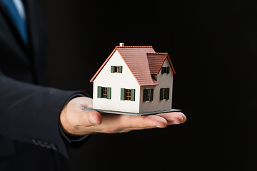 Image showing close up of businessman hand holding house model