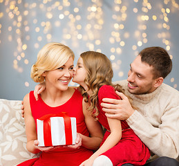 Image showing happy family with christmas gift kissing