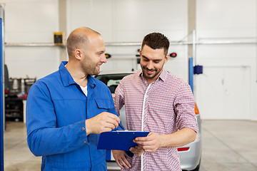 Image showing auto mechanic with clipboard and man at car shop