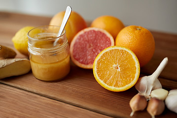 Image showing honey, citrus fruits, ginger and garlic on wood