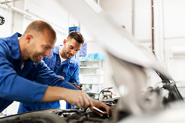 Image showing mechanic men with wrench repairing car at workshop