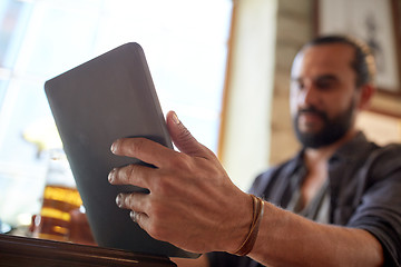 Image showing close up of man with tablet pc and beer at pub