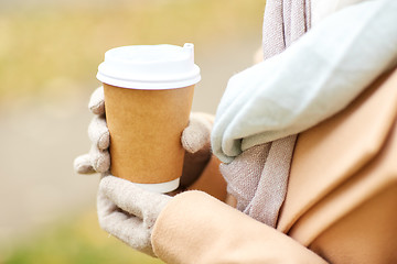 Image showing close up of woman with coffee in autumn park