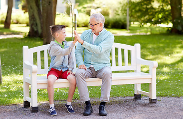 Image showing old man and boy making high five at summer park