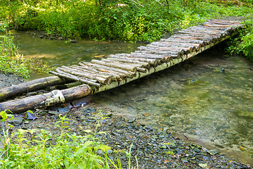 Image showing Wooden bridge over a small river forest