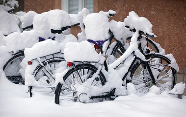 Image showing Snow covered Bikes in a Stockholm street