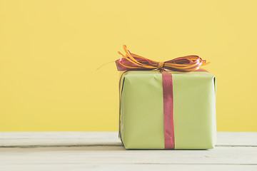 Image showing Green gift with a red and orange ribbon