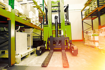 Image showing Forklift, shelves and racks with pallets in distribution warehou