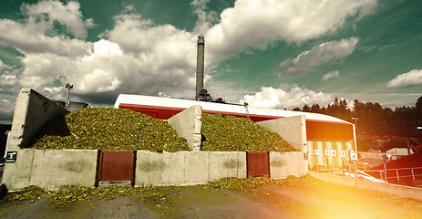 Image showing bio power plant with storage of wooden fuel against blue sky