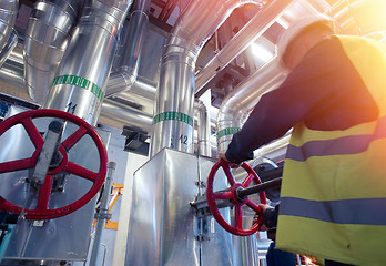 Image showing factory worker turning valve