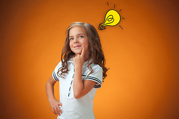 Image showing The cute cheerful little girl on orange background