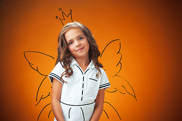 Image showing The cute cheerful little girl on orange background