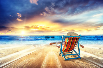 Image showing Woman in chaise-lounge relaxing at sunset 