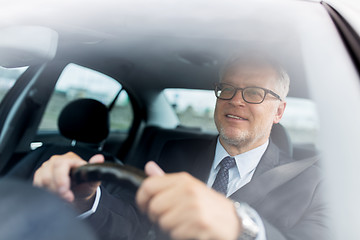 Image showing happy senior businessman driving car