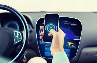 Image showing man driving car and setting eco mode on smartphone