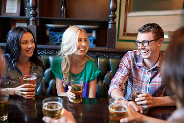 Image showing happy friends drinking beer at bar or pub