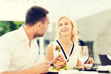 Image showing happy couple eating dinner at restaurant terrace