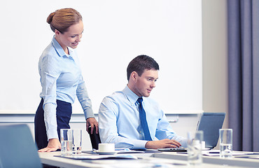 Image showing businessman and secretary with laptop in office