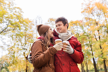 Image showing happy couple with coffee walking in autumn park