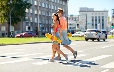 Image showing teenage couple with skateboards on city street